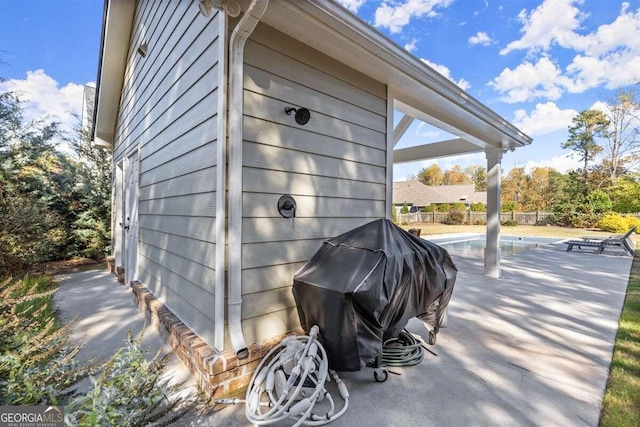 view of side of property featuring a patio area and a pool