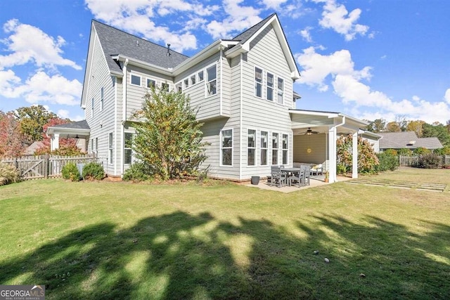 back of house featuring ceiling fan, a patio area, and a lawn