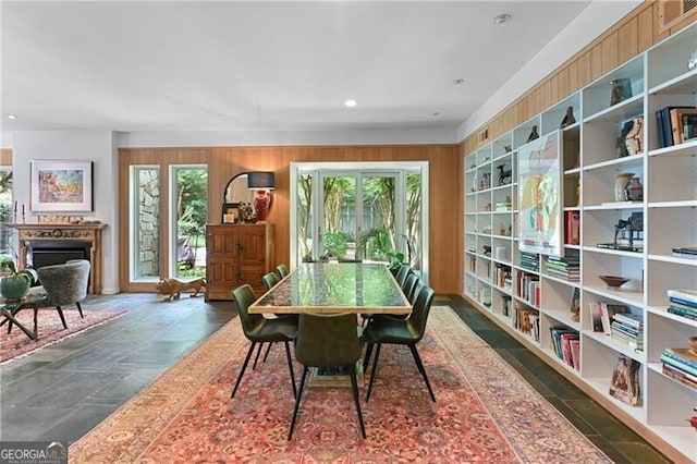 dining room featuring wooden walls and a healthy amount of sunlight