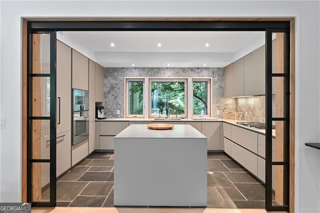 kitchen featuring tasteful backsplash, gray cabinetry, and a kitchen island