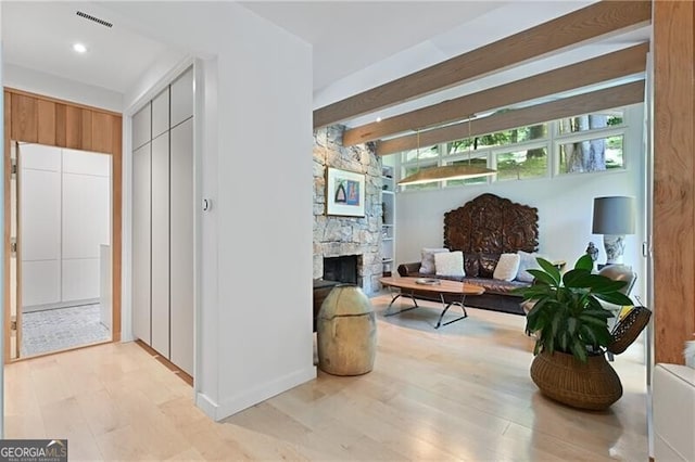 hallway with beam ceiling and light hardwood / wood-style flooring