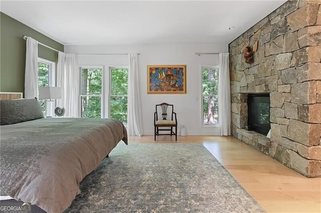 bedroom featuring a fireplace and light hardwood / wood-style floors