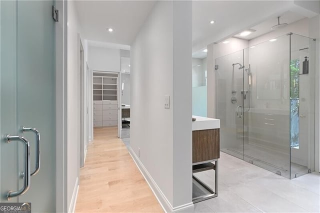 bathroom featuring a shower with door, vanity, and hardwood / wood-style flooring