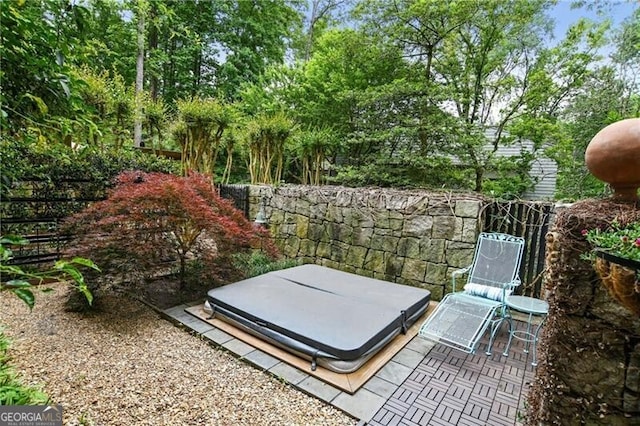 view of storm shelter with a hot tub and a patio area