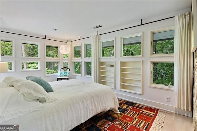 bedroom featuring wood-type flooring and multiple windows