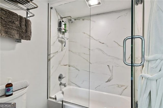 bathroom featuring combined bath / shower with glass door and toilet