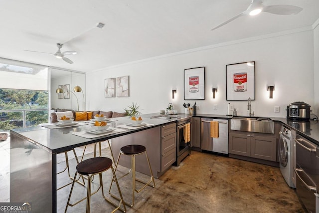 kitchen with kitchen peninsula, ornamental molding, stainless steel appliances, ceiling fan, and sink