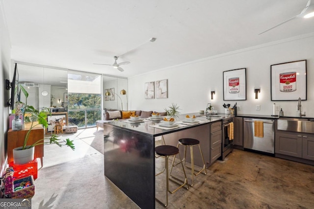 kitchen featuring kitchen peninsula, a kitchen bar, stainless steel appliances, ceiling fan, and sink