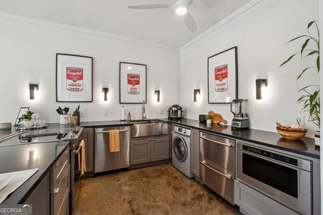 kitchen featuring appliances with stainless steel finishes, ornamental molding, ceiling fan, sink, and washer / dryer