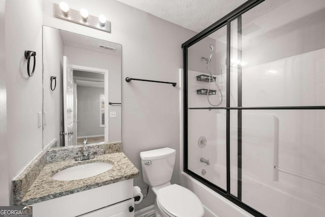 full bathroom with vanity, a textured ceiling, toilet, and enclosed tub / shower combo