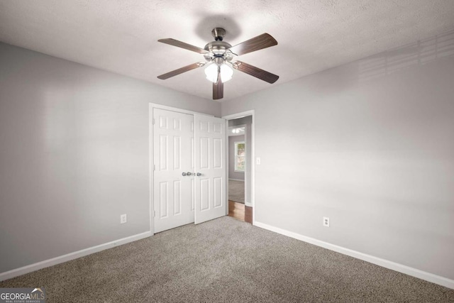 unfurnished bedroom featuring ceiling fan, a closet, carpet floors, and a textured ceiling