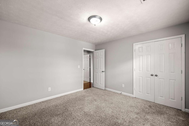 unfurnished bedroom featuring carpet flooring, a textured ceiling, and a closet