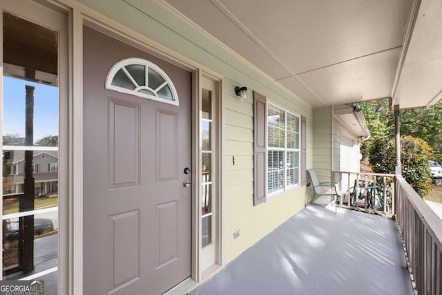 view of exterior entry featuring covered porch