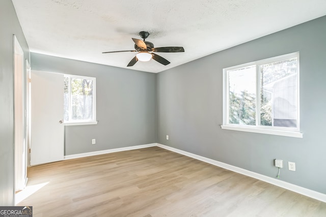 unfurnished room with a textured ceiling, light hardwood / wood-style flooring, and ceiling fan