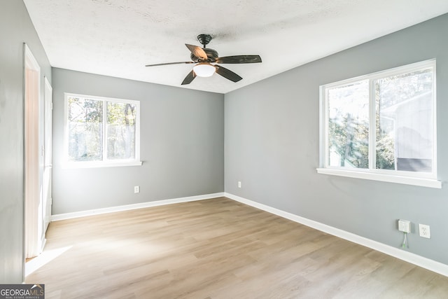 spare room featuring a textured ceiling, light hardwood / wood-style floors, and ceiling fan