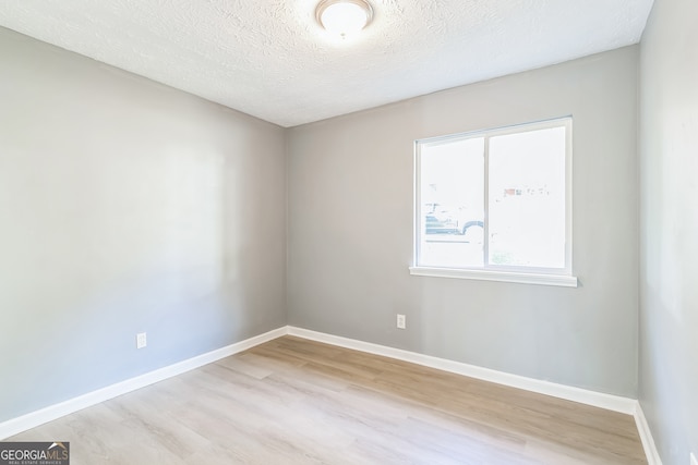 unfurnished room with light hardwood / wood-style floors and a textured ceiling