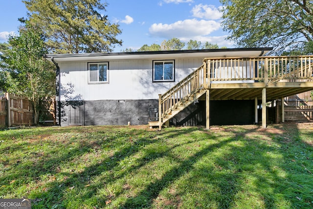 rear view of property with a deck and a yard