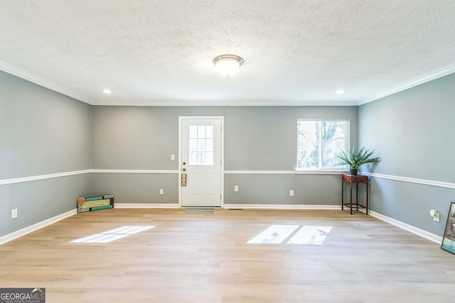 entrance foyer featuring a wealth of natural light, light hardwood / wood-style flooring, and crown molding