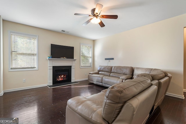 living room featuring ceiling fan and dark wood-type flooring