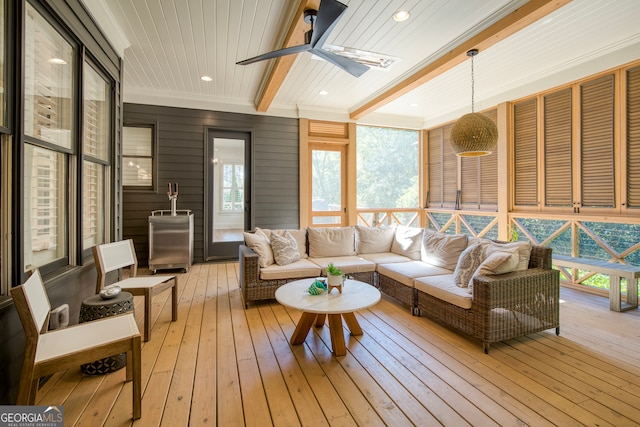 sunroom with beamed ceiling, ceiling fan, wooden ceiling, and a wealth of natural light