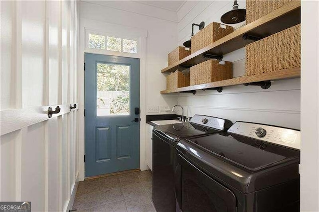 washroom featuring separate washer and dryer, sink, and light tile patterned floors