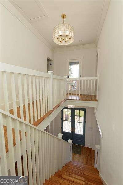 staircase featuring hardwood / wood-style flooring, plenty of natural light, and crown molding