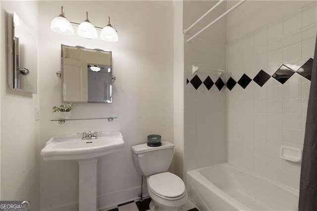 bathroom featuring tiled shower / bath and toilet