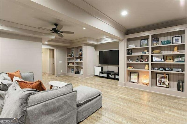 living room with a raised ceiling, ceiling fan, crown molding, and light hardwood / wood-style floors