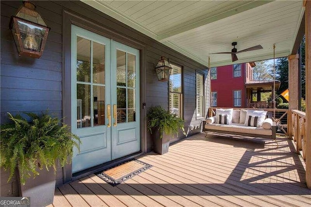 wooden terrace with ceiling fan, french doors, and covered porch