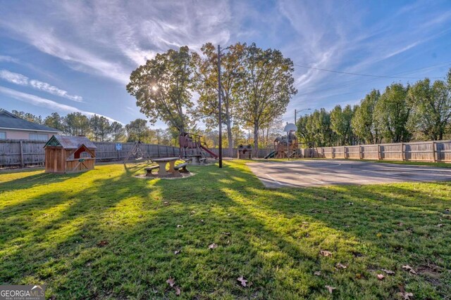 view of yard with a playground and a storage unit