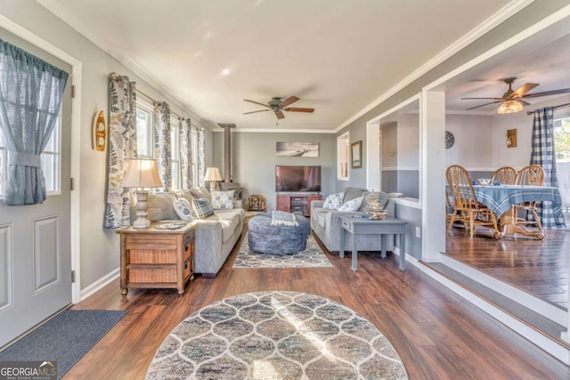 living room with ornamental molding, ceiling fan, and dark wood-type flooring