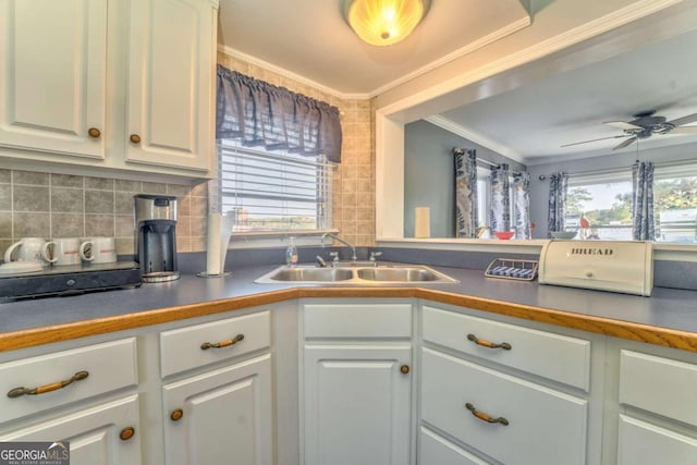 kitchen featuring backsplash, white cabinetry, and sink