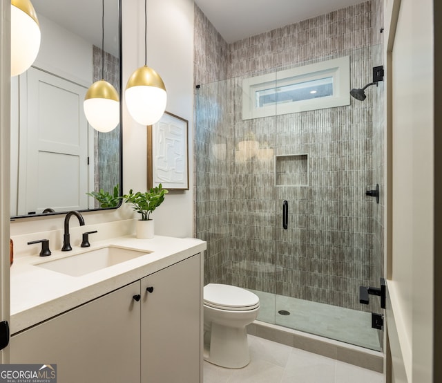 bathroom featuring tile patterned flooring, vanity, toilet, and a shower with door