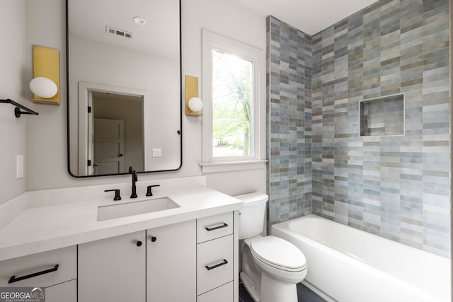 full bathroom featuring vanity, toilet, and tiled shower / bath combo