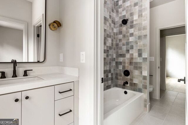 full bathroom featuring tile patterned flooring, vanity, tiled shower / bath combo, and toilet