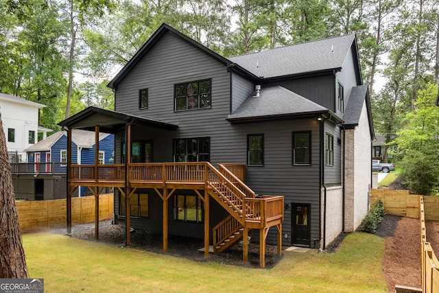 rear view of property featuring a deck and a yard