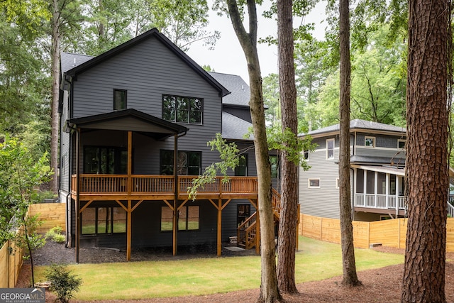 rear view of house with a yard and a wooden deck