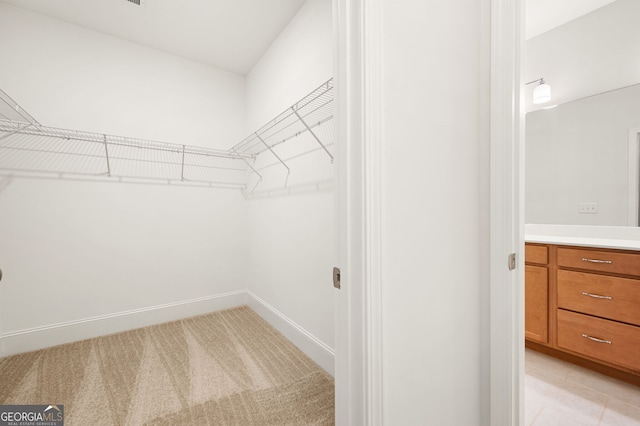 walk in closet featuring light colored carpet