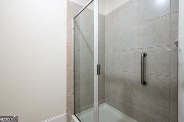 bathroom featuring a shower with shower door