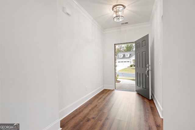 foyer entrance with ornamental molding and dark hardwood / wood-style flooring