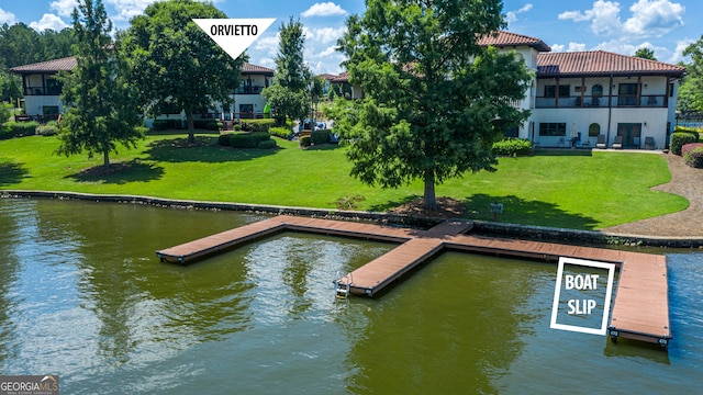 dock area with a balcony, a yard, and a water view