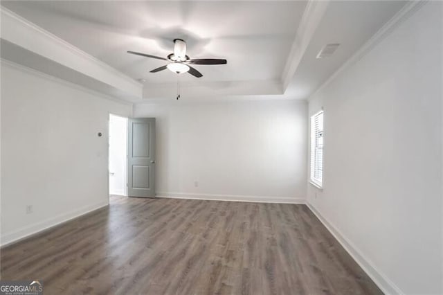 unfurnished room with dark hardwood / wood-style floors, ceiling fan, ornamental molding, and a tray ceiling