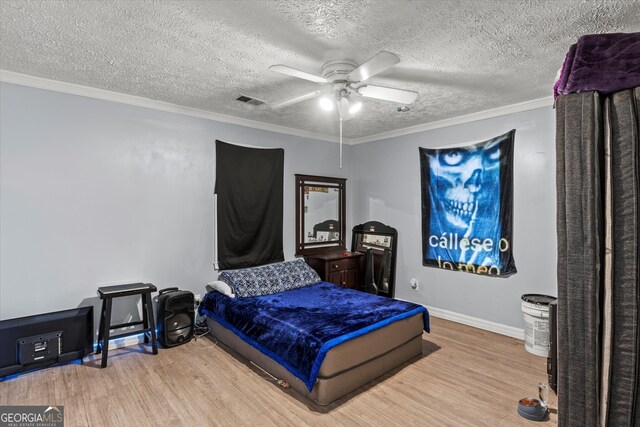 bedroom featuring ceiling fan, crown molding, a textured ceiling, and light wood-type flooring