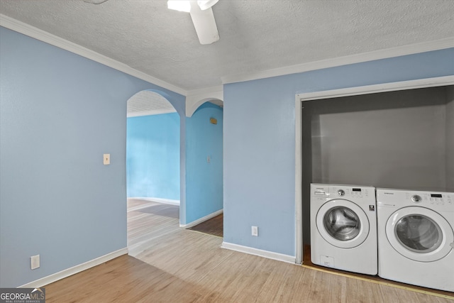 laundry room with washer and clothes dryer, hardwood / wood-style floors, a textured ceiling, and ornamental molding