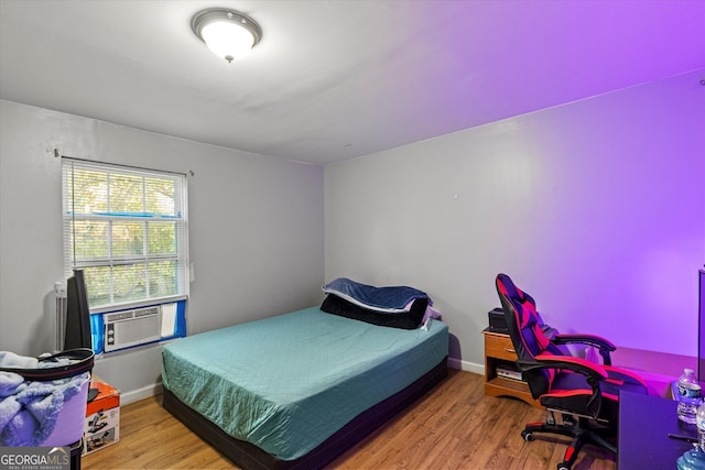 bedroom featuring wood-type flooring and cooling unit