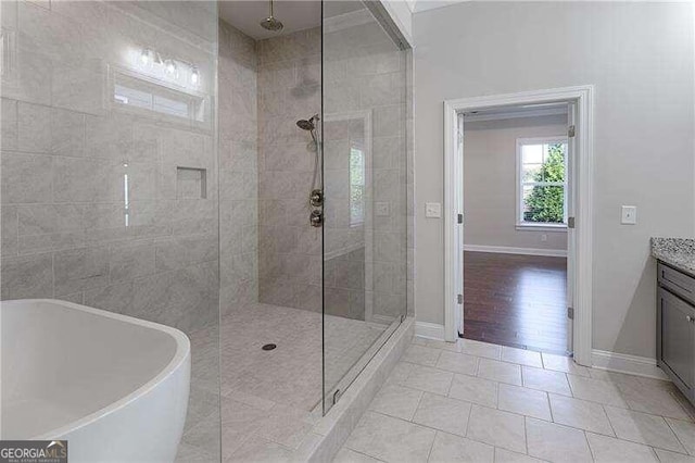 bathroom with hardwood / wood-style flooring, vanity, and shower with separate bathtub