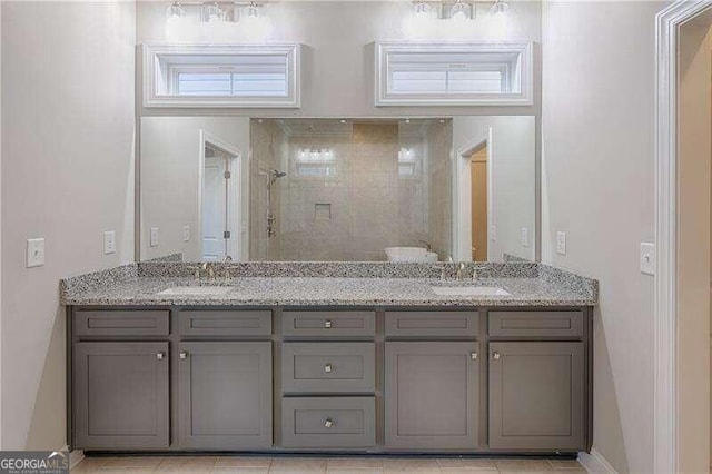 bathroom with a tile shower, tile patterned flooring, and vanity