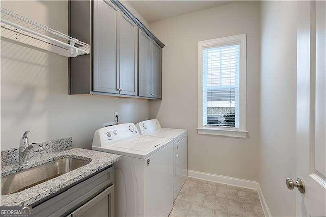 laundry room with washer and clothes dryer, cabinets, and sink