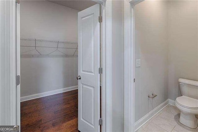 bathroom featuring wood-type flooring and toilet