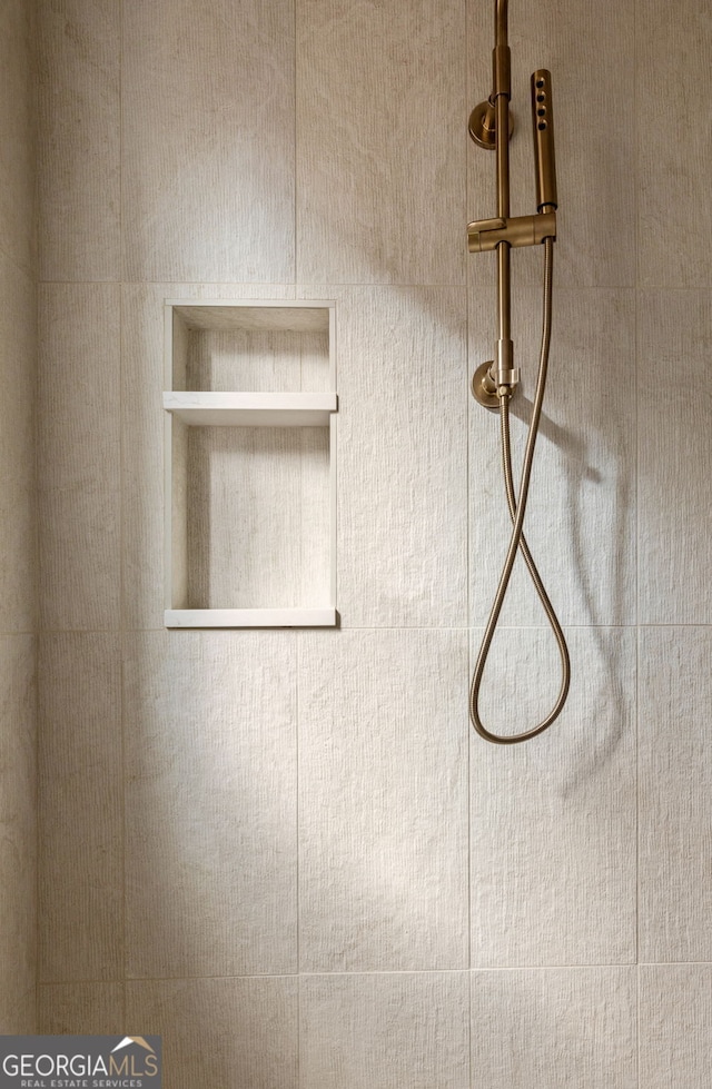 interior details featuring tiled shower